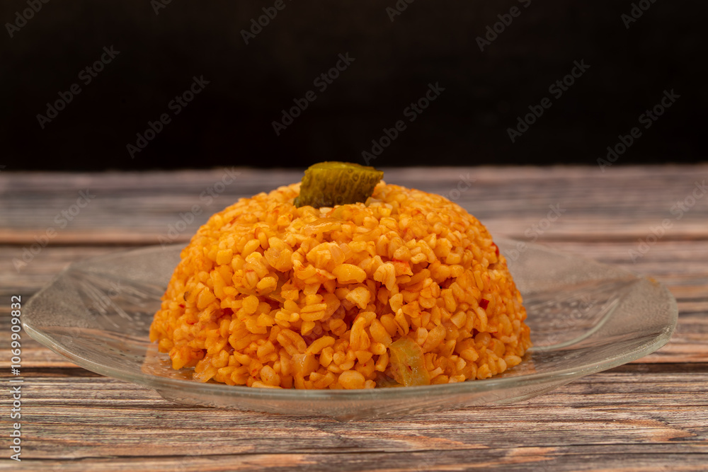 Traditional turkish bulgur pilaf with tomato sause in plate (Turkish name; meyhane pilavi)