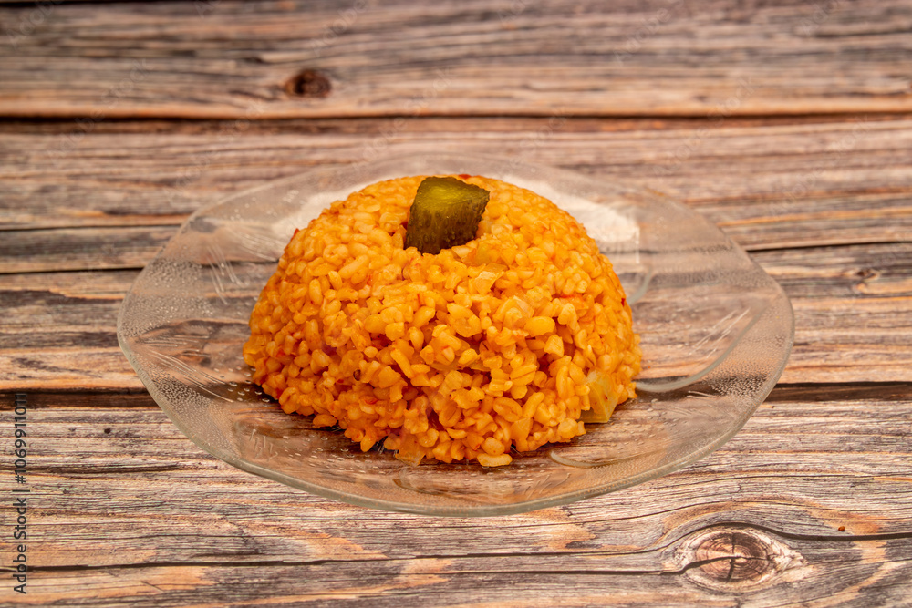 Traditional turkish bulgur pilaf with tomato sause in plate (Turkish name; meyhane pilavi)