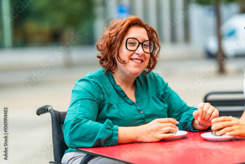 Foto Woman with disability using electric wheelchair drinking coffee with friend