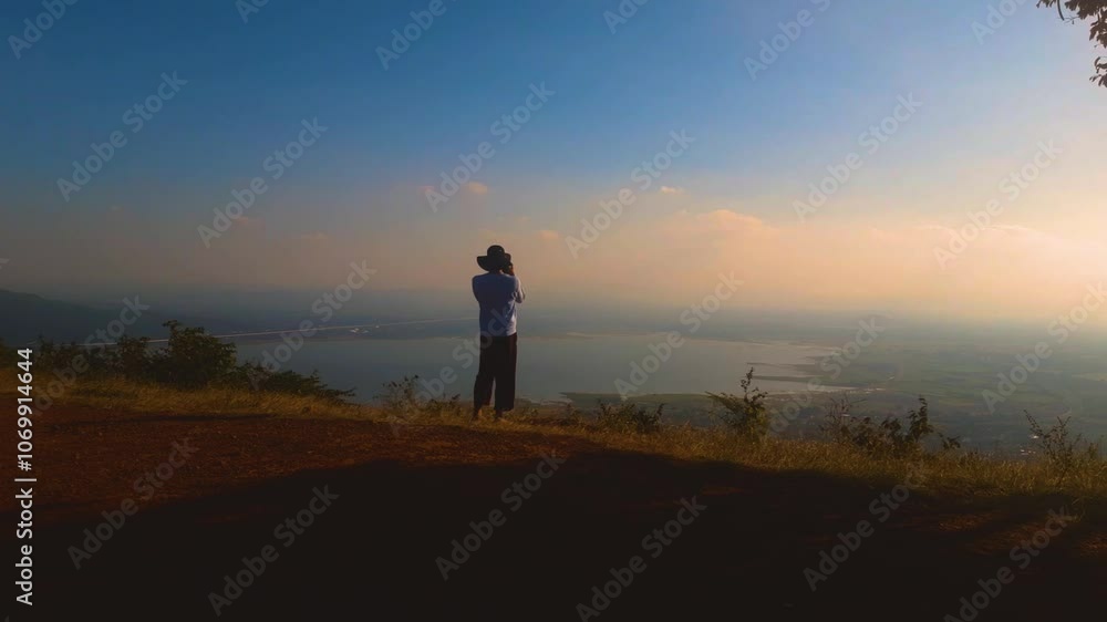 silhouette of a person standing on a hill, take a photo silhouette of a person standing on a hill, take a photo