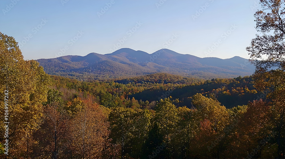Fototapeta premium Panoramic view of a mountainous landscape with fall foliage in the foreground.