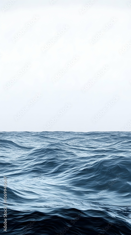 Fototapeta premium A panoramic view of the ocean with gentle waves and a clear blue sky.