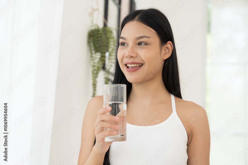 Young Asian woman drinking water in home. Health care concept Young Asian woman drinking water in home. Health care concept