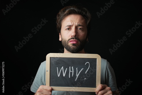 Caucasian Man holding a Chalkboard with the Handwritten word  "Why?"