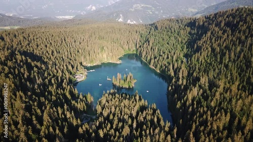 Aerial shot of the stunning Cauma Lake, Caumasee, a picturesque alpine lake nestled amidst a dense forest and majestic mountains in Graubünden, Switzerland photo