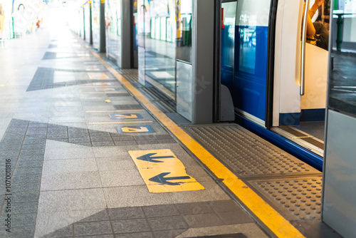 Wallpaper Mural Subway platform arrow sign indicating direction entrance and exit on textured floor at train station. Torontodigital.ca