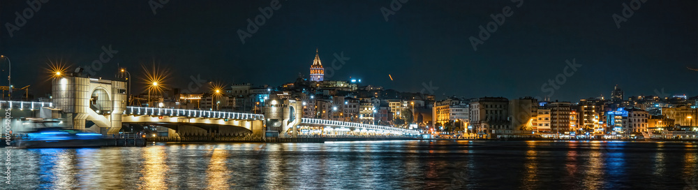 Obraz premium The historical symbol of Istanbul, Galata Tower. View of Istanbul in the dark at night. The unique view of the sea and Galata Tower combined.Istanbul, Turkey.
