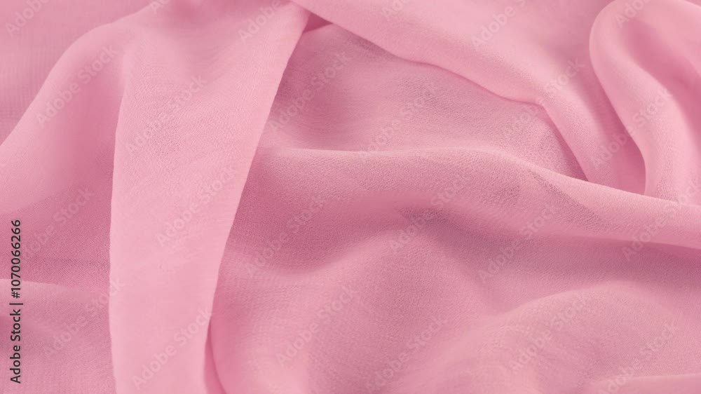 Close-up view of the soft folds of thin electric lavender purple color chiffon fabric on a rotating display case. Textile background with sewing accessories on the theme of fashion, design. Close-up view of the soft folds of thin electric lavender purple color chiffon fabric on a rotating display case. Textile background with sewing accessories on the theme of fashion, design.