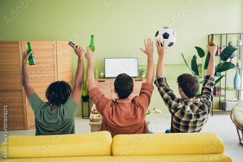 Rear photo of company three friends hang out watch tv football weekend modern interior apartment indoors photo