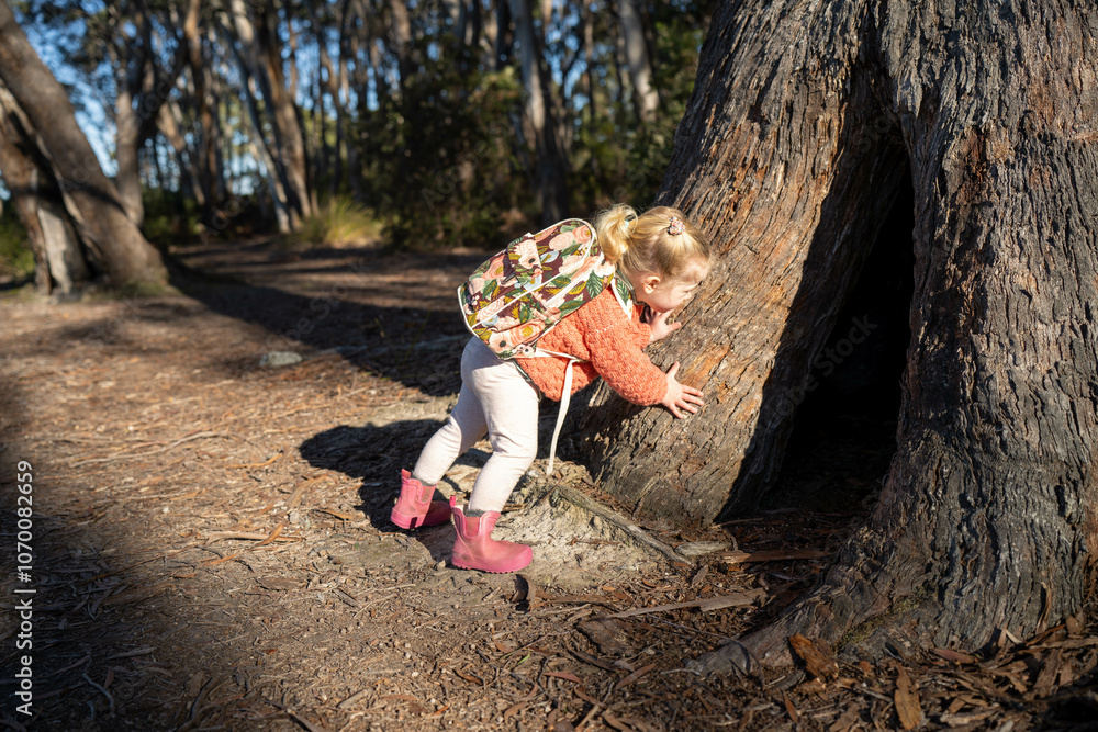 family with a toddler and children walking in nature exploring and learning, hiking in the trees and gardens. self playing