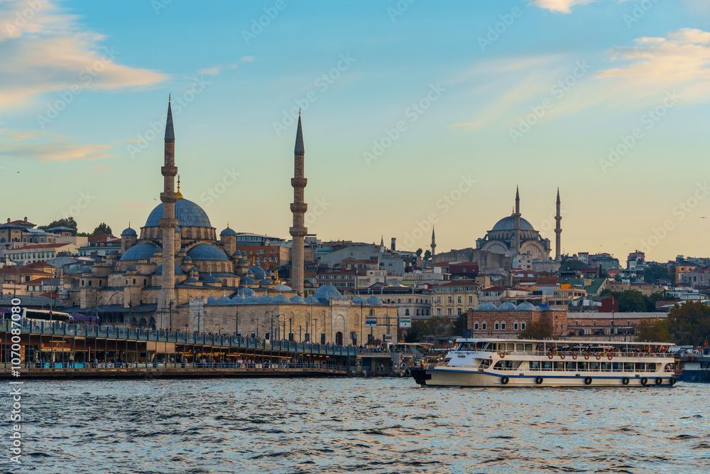 Naklejka premium cityscape of Istanbul, Turkey, view to the Golden Horn Bay and architecture of city and ships and Bosphorus shore against the sunset sky, a popular tourist destination