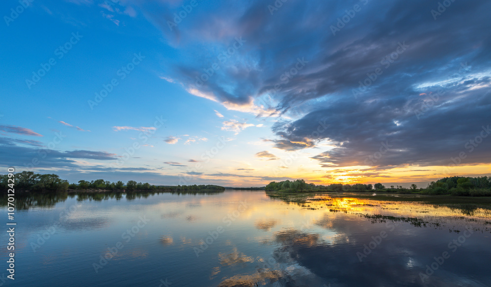 Beautiful sunset over a lake with a reflection of the sky on the water Beautiful sunset over a lake with a reflection of the sky on the water