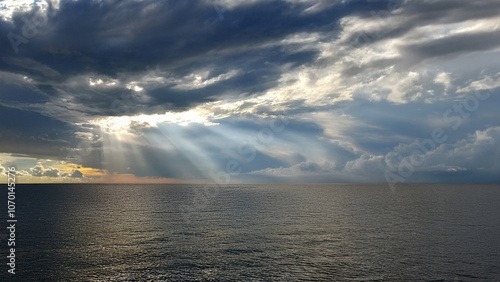 sonnenstrahlen fallen aus den wolken aufs meer photo