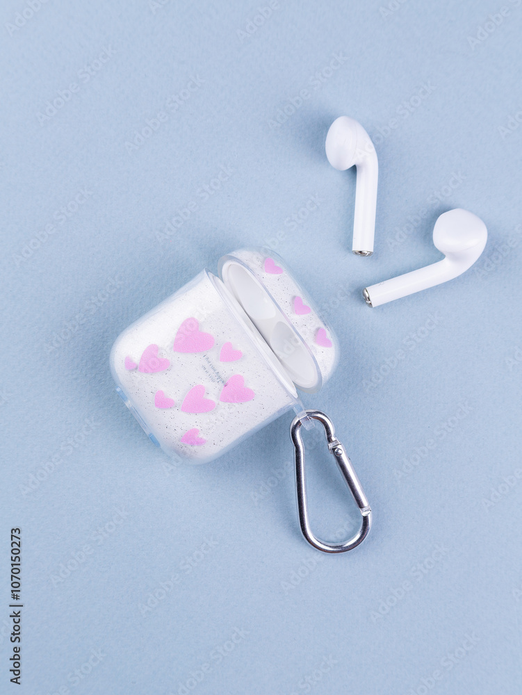 Close up of wireless headphone case with cute print on table Close up of wireless headphone case with cute print on table