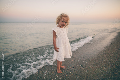 Little Girl in White Dress by the Seashore at Sunset