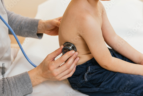 Fotografie Doctor examining child's lungs with stethoscope during checkup