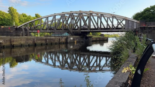 Barton Swing Bridge over Manchester Ship Canal; bicycle rider, cars and other transport driving over former River Irwell on metal arch construction swinging bridge. photo