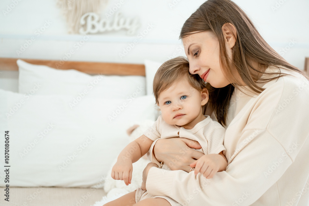 mom and baby on the bed at home hugging and kissing, mother and child playing and having fun, happy motherhood and a young family mom and baby on the bed at home hugging and kissing, mother and child playing and having fun, happy motherhood and a young family
