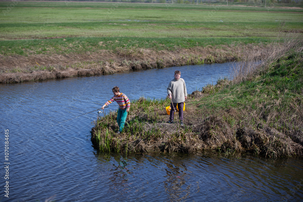 The boys are fishing on a small river. Friends go fishing in the summer. The boys are fishing on a small river. Friends go fishing in the summer.
