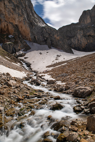 Long exposure river, stream. Glacial valleys and streams. Blue sky and snowy mountains. Snowy mountains of Tunceli. Pülümür Valley, Buyer Mountain, Sarıgül Plateau, Buyer Waterfall. Türkiye. photo