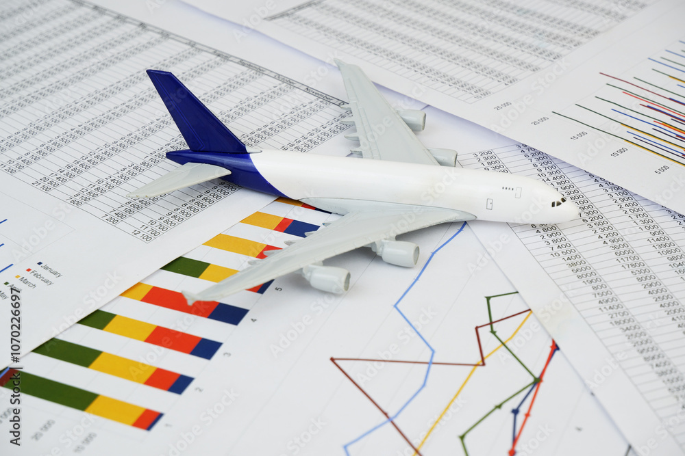 Airplane model on many financial reports. Cargo and shipping prices concept. Airplane model on many financial reports. Cargo and shipping prices concept.
