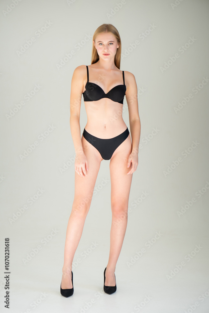 Close view of beautiful slim woman body in black underwear in the studio. Close view of beautiful slim woman body in black underwear in the studio.