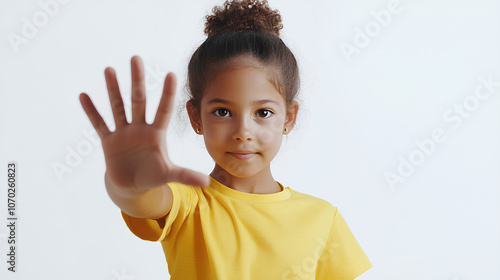 a girl in a yellow T-shirt stretches her hand forward giving a stop sign, denial, on a white background