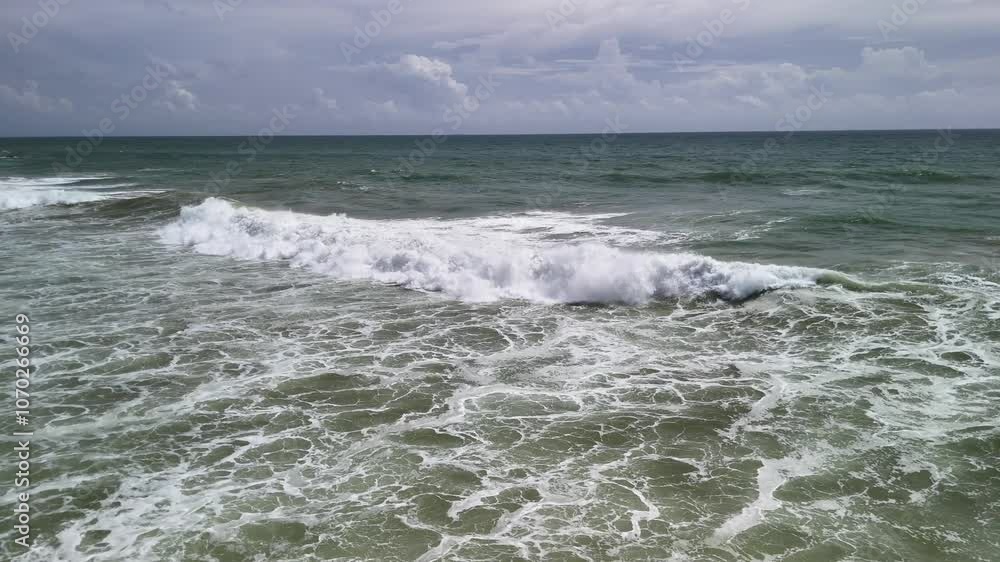 Ocean water waves brown green color calm sea, aerial above, cloudy skyline Ocean water waves brown green color calm sea, aerial above, cloudy skyline