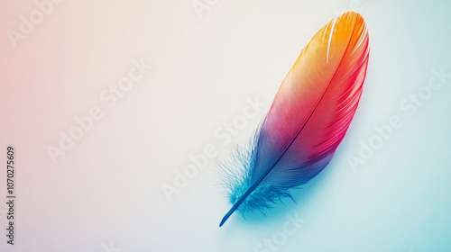 A colorful feather resting on a smooth surface with a white background, showcasing vibrant hues and delicate textures