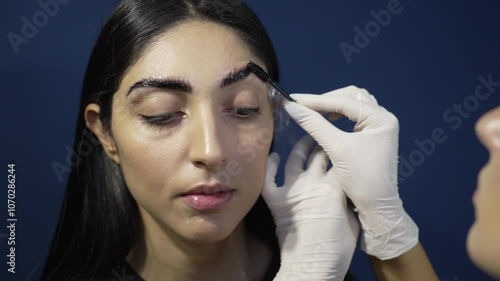 Microblading Magic: Brushing and Oiling the Perfect Brows Closeup of Young Woman's Face photo