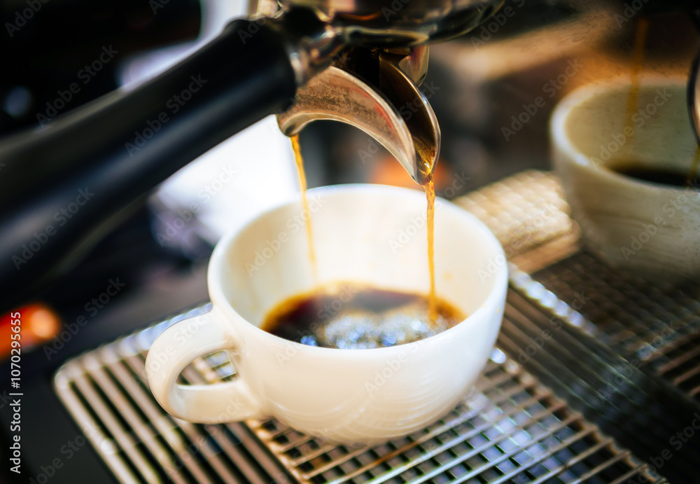 Close-up of Americano pouring from the coffee machine into a cup. Professional coffee brewing black coffee Close-up of Americano pouring from the coffee machine into a cup. Professional coffee brewing black coffee