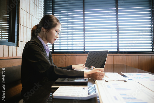 Business accounting concept. Asian businesswoman working with her laptop, calculator and documents in the office.