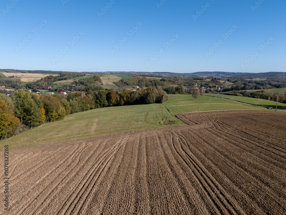 Aerial view of lush green fields and distant hills under a clear blue sky. Perfect for nature-themed projects. Aerial view of lush green fields and distant hills under a clear blue sky. Perfect for nature-themed projects.