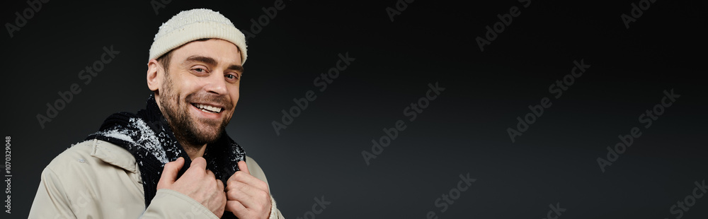 Charming young man with a beanie smiles warmly against a black background in a cozy setting Charming young man with a beanie smiles warmly against a black background in a cozy setting