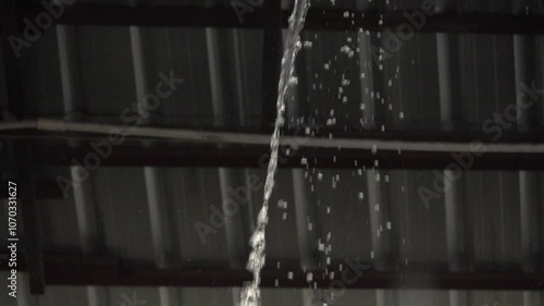 A roof is leaking water and the water is dripping from the ceiling
