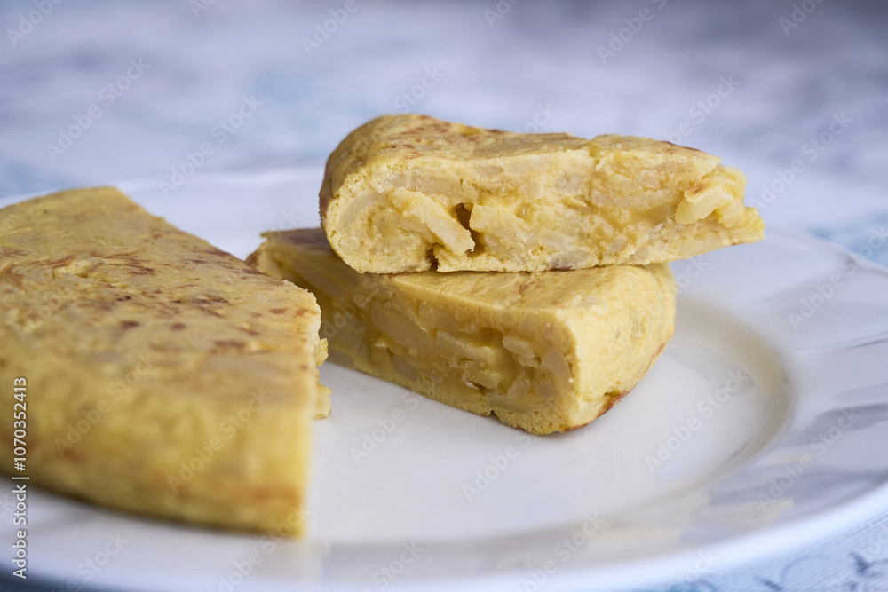 Small portions of Spanish omelette made with eggs, potato and onion on a plate. Typical tapas of Spanish cuisine. Small portions of Spanish omelette made with eggs, potato and onion on a plate. Typical tapas of Spanish cuisine.