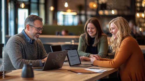 Business group using laptops collaboratively at shared desk in modern office. AI generated