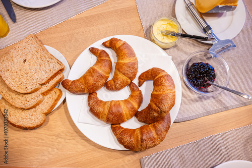 Typical European Sunday morning breakfast with fresh croissants and orange juice photo