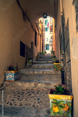 Narrow street in the old town of Cefalu in Sicily, Italy in a beautiful summer day. Travel and sightseeing journey concept