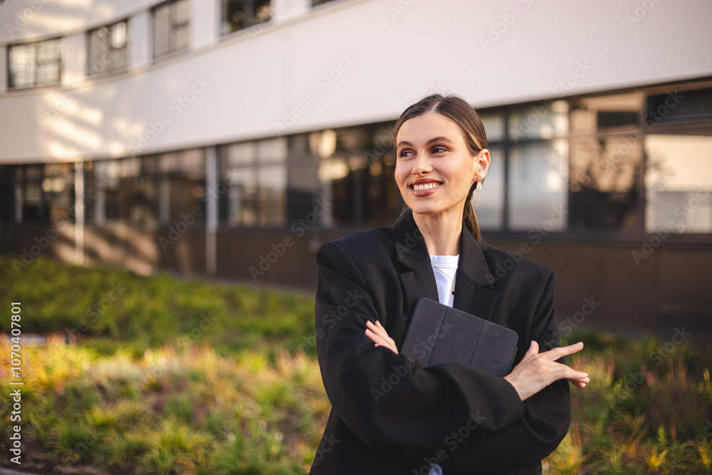 Woman entrepreneur with ponytail crossed hands hold tablet is standing on office building background. Successful smiling caucasian woman in business suit. Female worker with crossed arms look happy. Woman entrepreneur with ponytail crossed hands hold tablet is standing on office building background. Successful smiling caucasian woman in business suit. Female worker with crossed arms look happy.