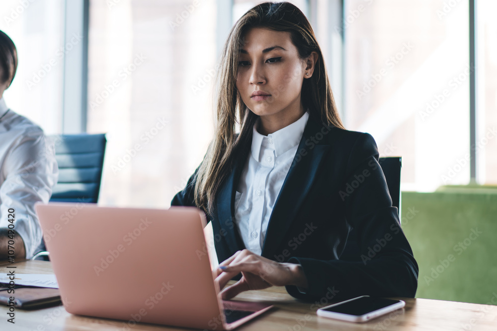 Concentrated businesswoman typing on laptop at table Concentrated businesswoman typing on laptop at table