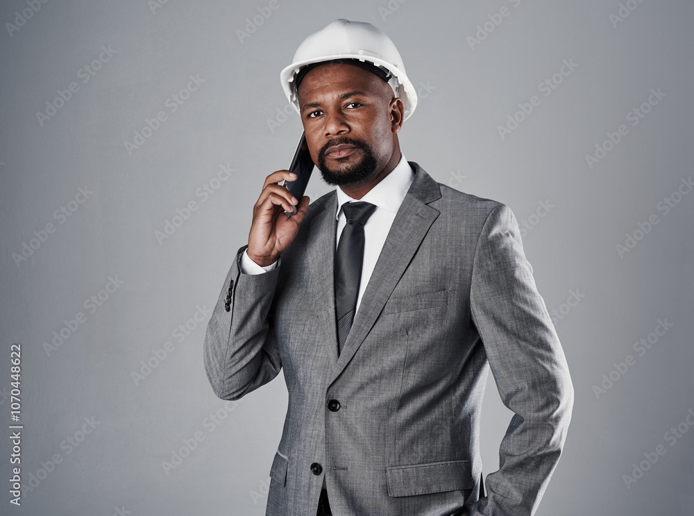 Phone call, construction and portrait of man in studio for architecture, engineering and building project. Contractor, gray background and person on smartphone for contact, conversation and talking Phone call, construction and portrait of man in studio for architecture, engineering and building project. Contractor, gray background and person on smartphone for contact, conversation and talking