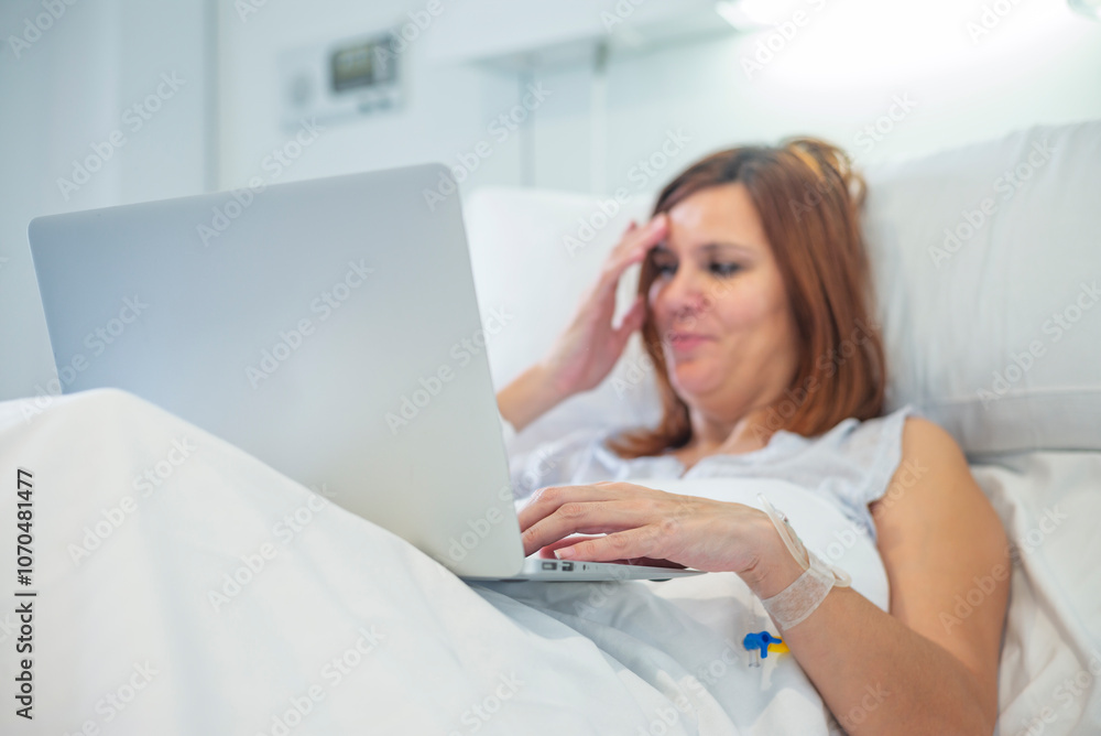 Woman in hospital bed with laptop, looking relaxed and focused on digital activity. Woman in hospital bed with laptop, looking relaxed and focused on digital activity.