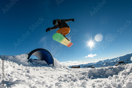 Elevated snowboarding. Springboard launch lifts rider in graceful jump. photo