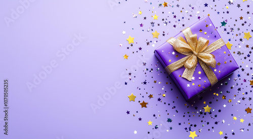 Wallpaper Mural purple gift box with a golden ribbon and star-shaped confetti on a lilac background, viewed from above. Birthday or Christmas present concept.  Torontodigital.ca