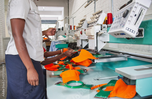 african american women working in digital computer electronic embroidery machine multiple head industrial, working in a apparel textile factory photo