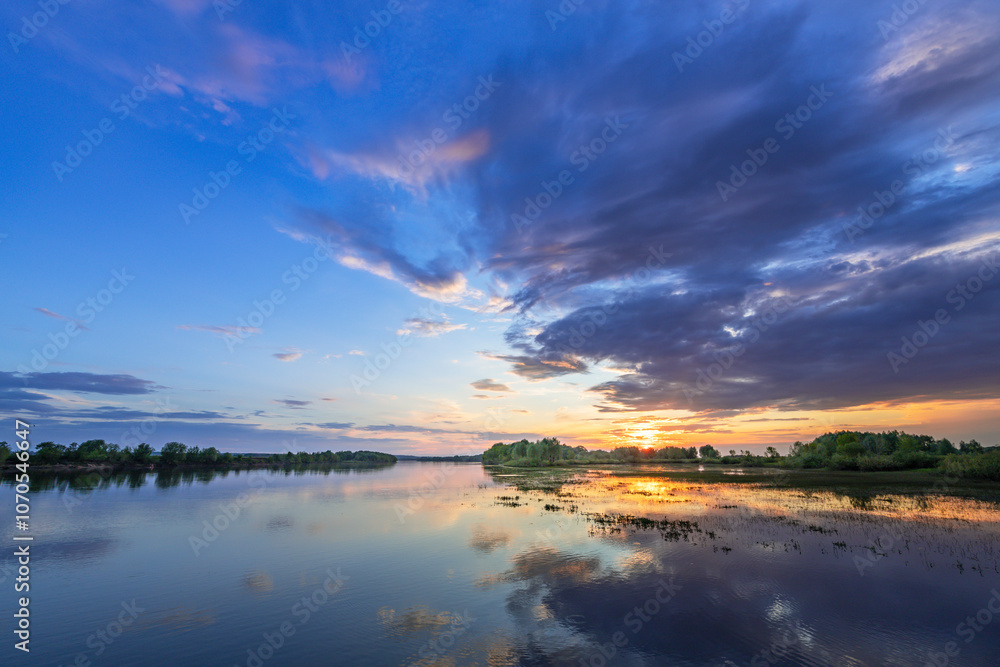 Beautiful sunset over a lake with a few trees in the background Beautiful sunset over a lake with a few trees in the background
