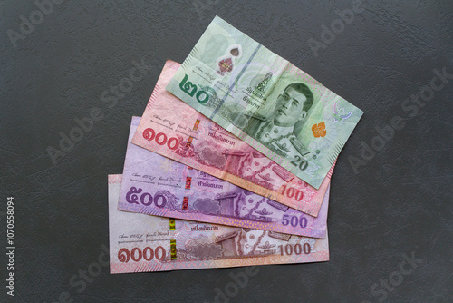 Thai Baht Banknotes on Table. Close-up of Thai Baht banknotes spread on a table, highlighting the currency.