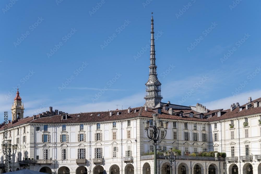 Fototapeta premium Mole Antonelliana spire looms out of old buildings on Vittorio Veneto square, Torino, Italy
