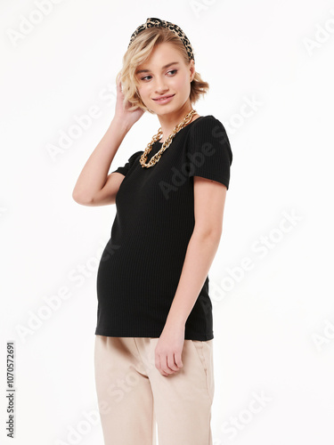 Pregnant girl model in casual clothing, photographing in the studio on a light background.